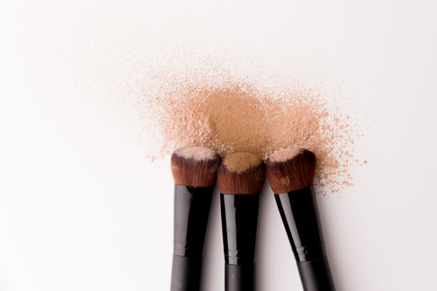 three-makeup-brushes-with-mineral-makeup-on-them