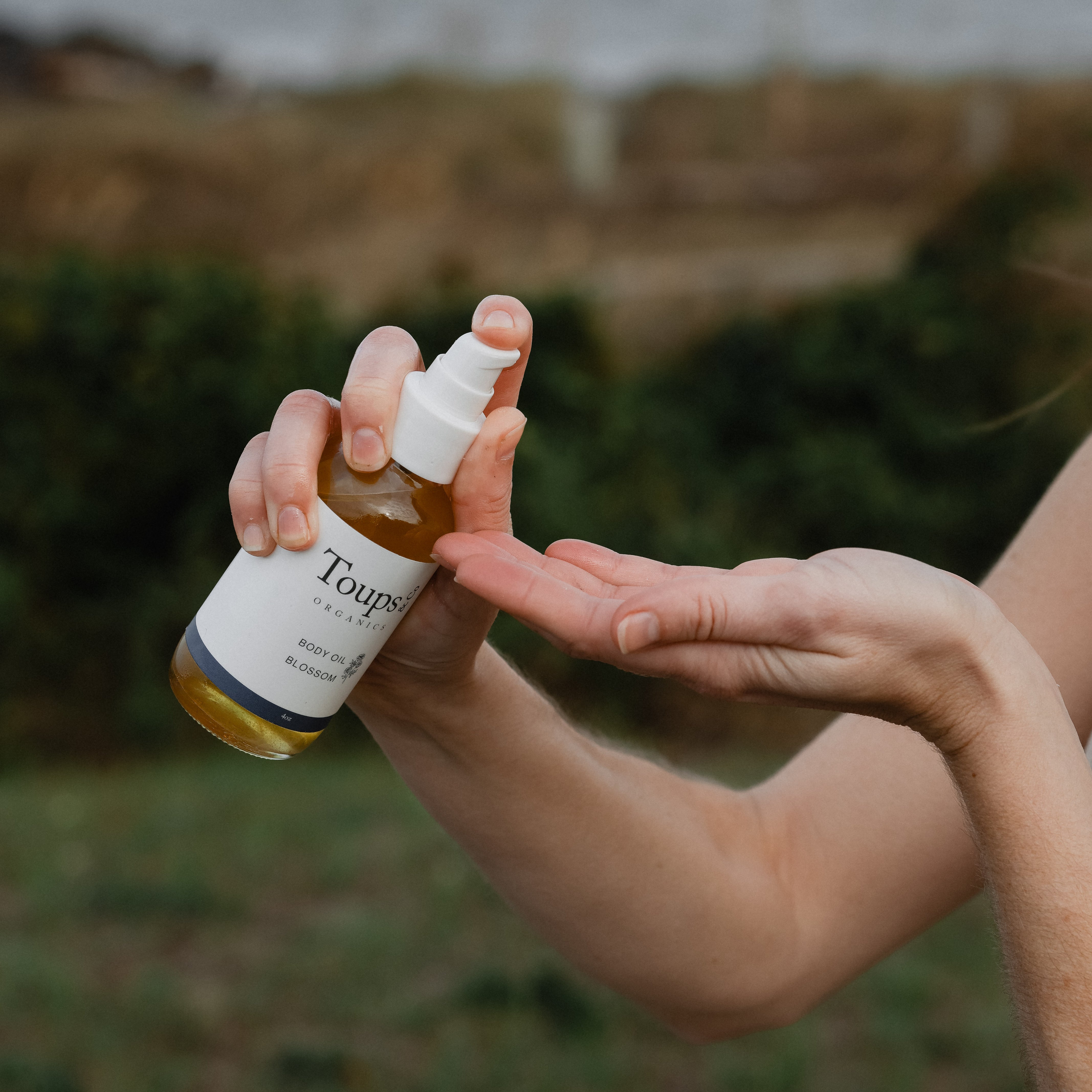 woman-spraying-body-oil-into-palm