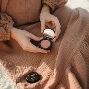 woman-holds-nontoxic-powder-blush-product-open-to-show-pigment
