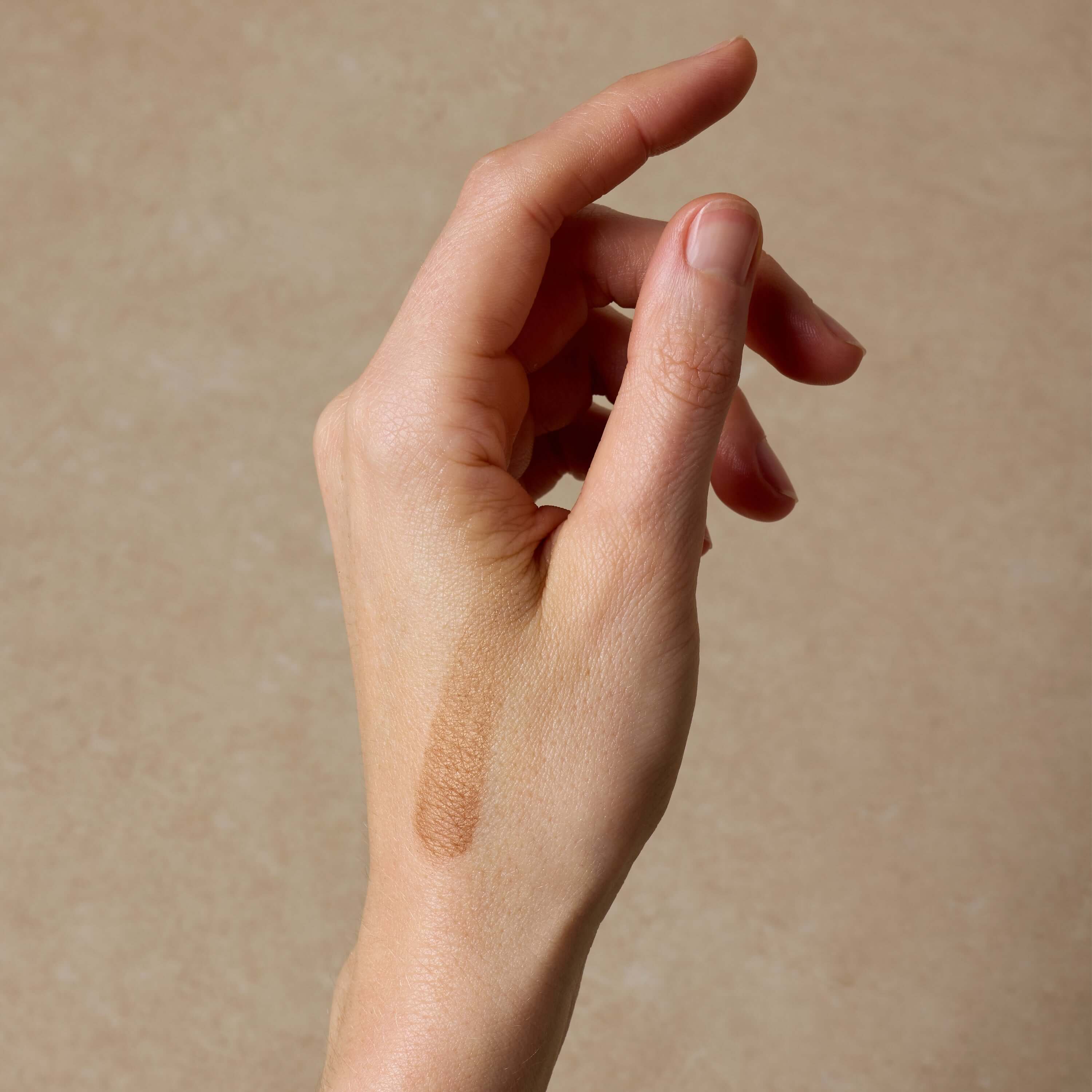woman-shows-swatch-of-nontoxic-makeup-bronzer-on-her-hand