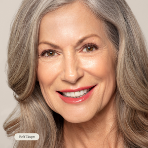 Close-up of an older woman with long gray hair, smiling, wearing natural makeup with soft taupe lipstick and perfectly defined brows using the Brow Pencil from Toups and Co Organics for a buttery smooth application.