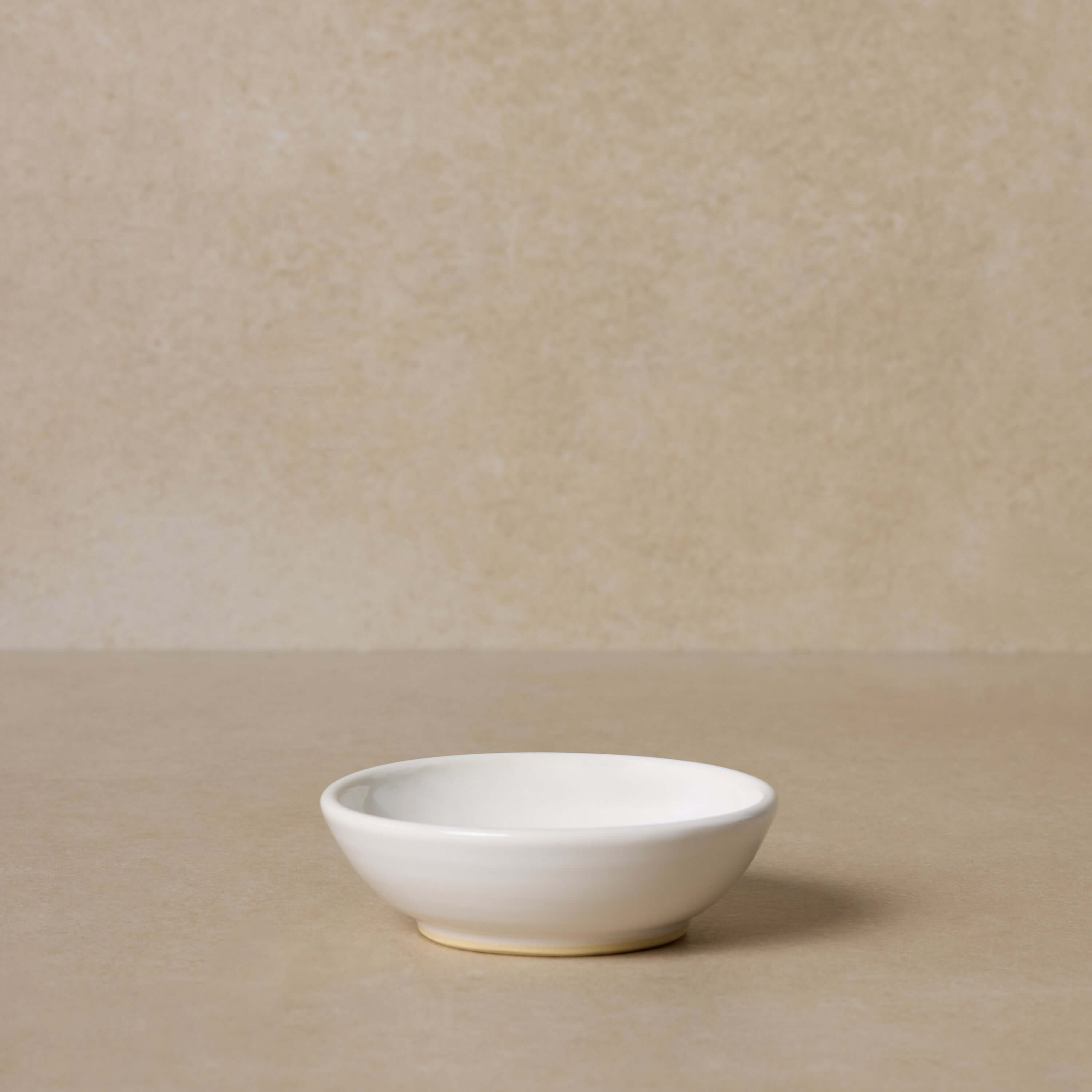 white-pottery-bowl-for-mixing-face-masks-displayed-on-brown-background