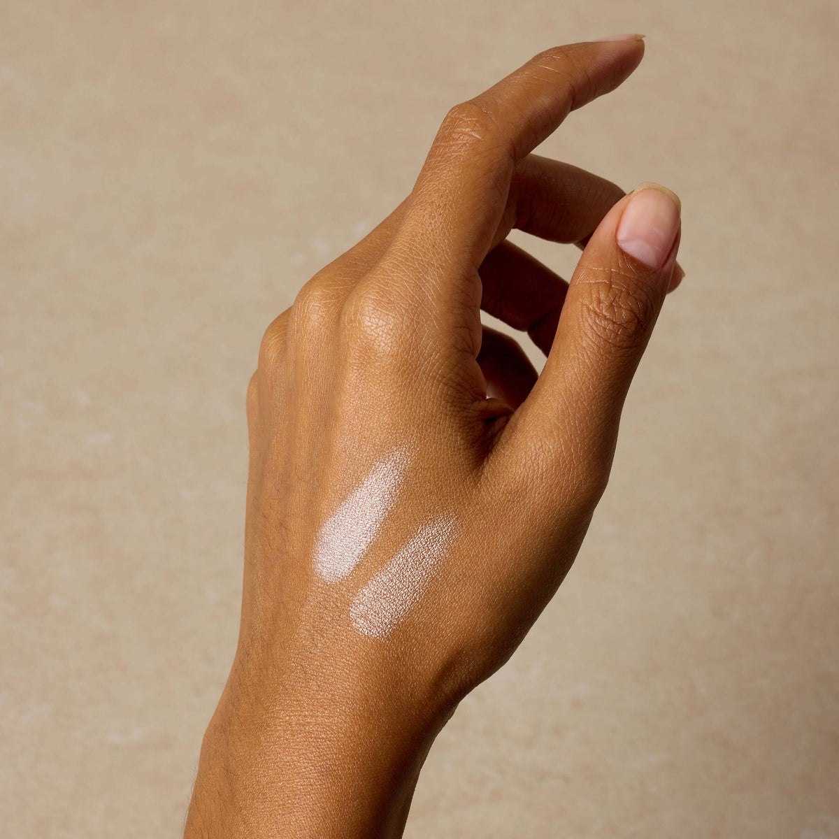 woman-swatches-cream-luminizer-shade-on-hand