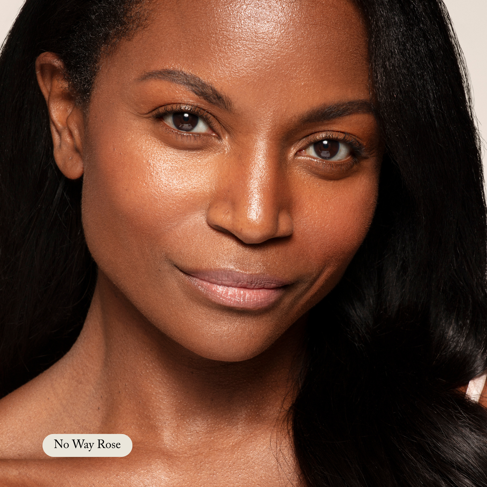 A woman with smooth, medium-dark skin and long black hair smiles softly at the camera, her lips enhanced by Toups and Co Organics Organic Lip Gloss. The label No Way Rose appears in the lower left corner.