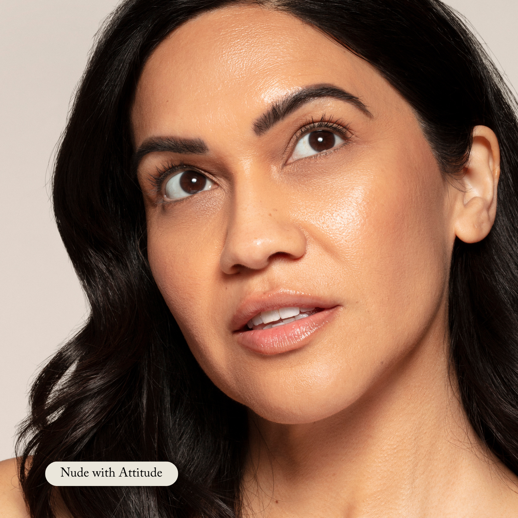 A woman with medium skin and dark hair looks upward, wearing Toups and Co Organics Organic Lip Gloss—a safe, nontoxic, moisturizing formula in a glossy nude shade.