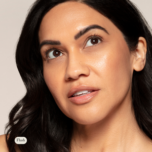 A woman with medium skin and dark wavy hair looks upward, wearing natural makeup with a dewy finish and a touch of Toups and Co Organics Natural Pressed Blush.