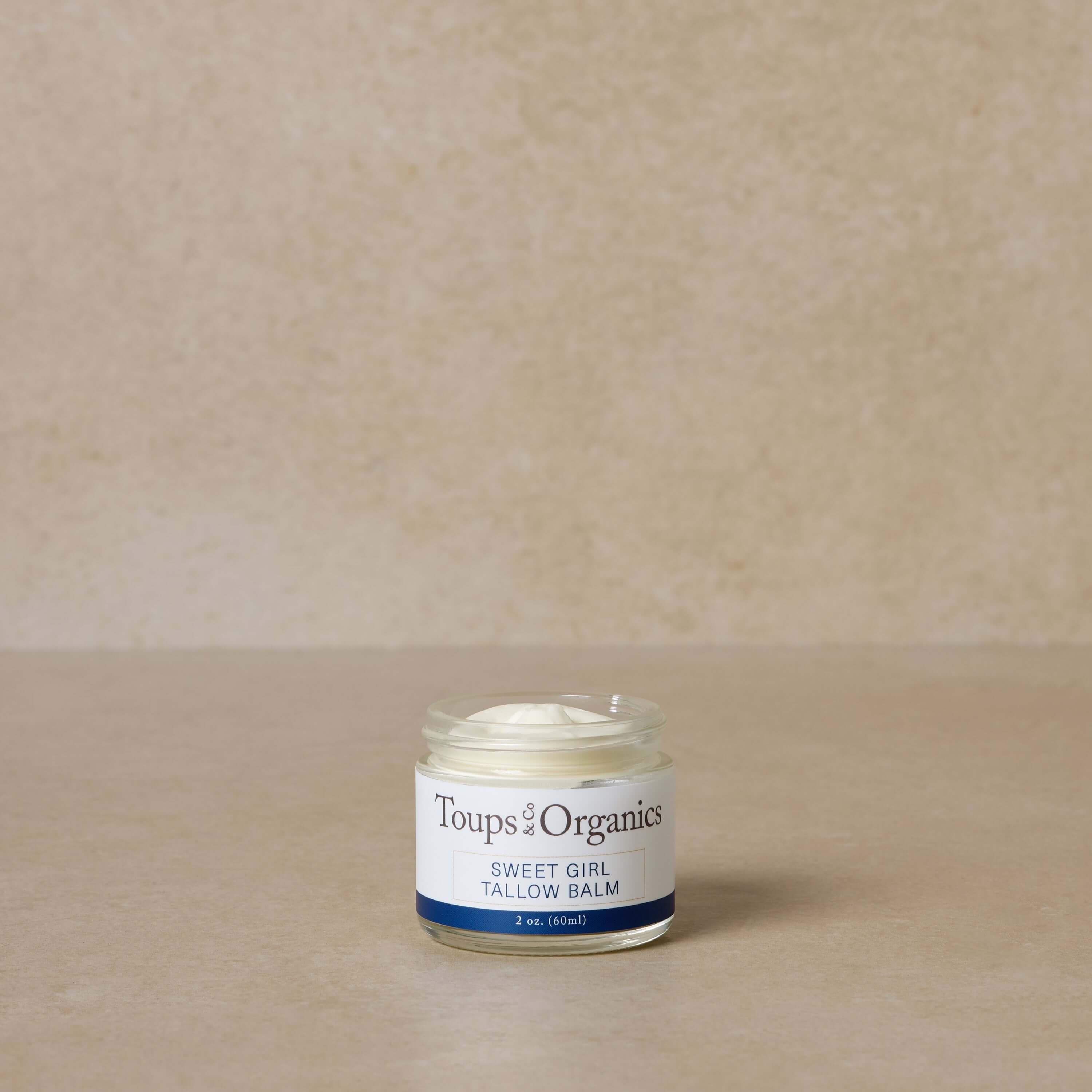 A glass jar labeled Toups and Co Organics Spa Gift Set sits open on a beige surface against a neutral background, perfect for skin hydration and nontoxic skincare.