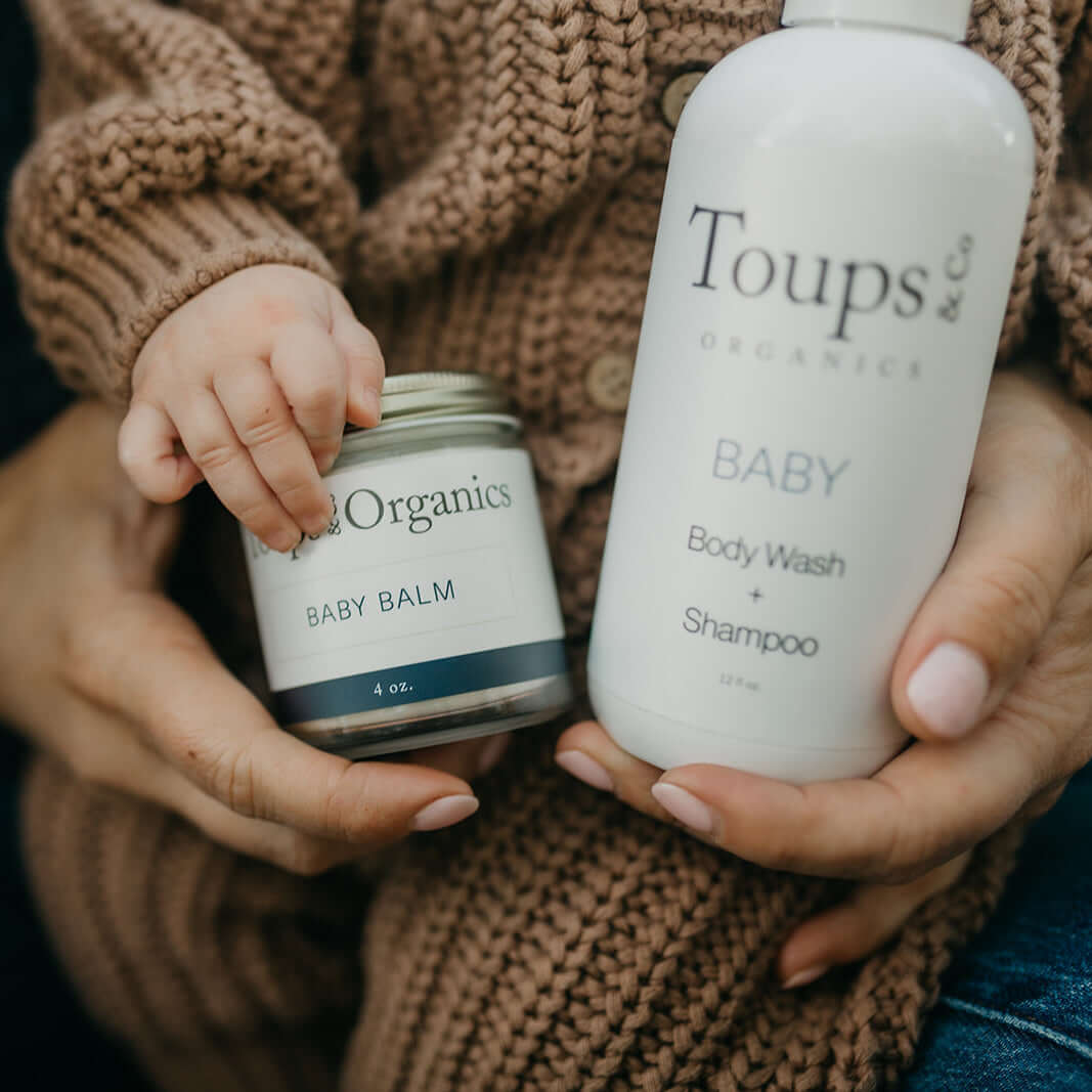 cute-baby-holds-body-wash-and-tallow-balm-products