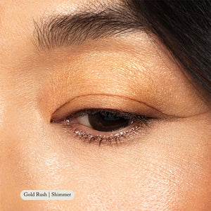 Close-up of a persons eye with shimmery gold, highly pigmented Natural Eyeshadow Singles by Toups and Co Organics applied to the lid. A label at the bottom reads Gold Rush | Shimmer.