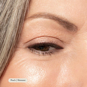 Close-up of a womans eye with smooth skin and defined brow, showcasing Toups and Co Organics Natural Eyeshadow Singles for an effortless everyday look. Corner text: Peach | Shimmer.