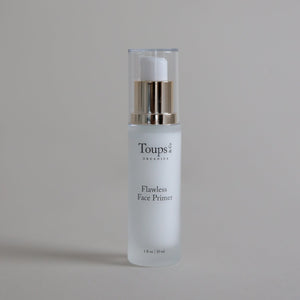A bottle of Toups and Co Organics Flawless Face Primer with a pump dispenser rests on a neutral surface.