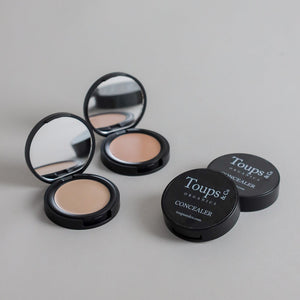Toups & Co non-toxic concealers photographed open and closed on a soft grey seamless background, showcasing the creamy complexion product and sleek black packaging. Clean, minimalist product photography for natural makeup and everyday beauty.