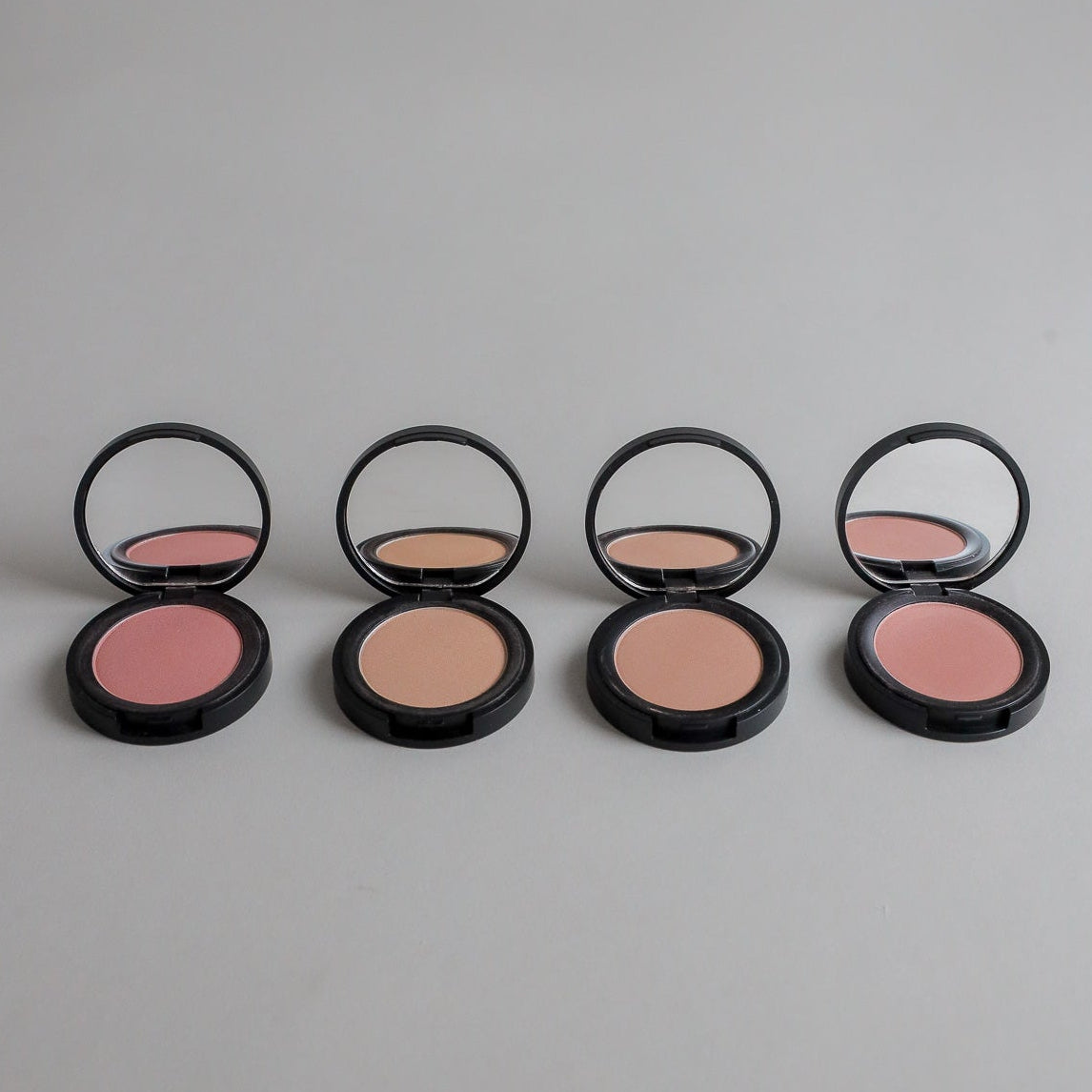 Four shades of natural pressed mineral blush compacts open with mirrors