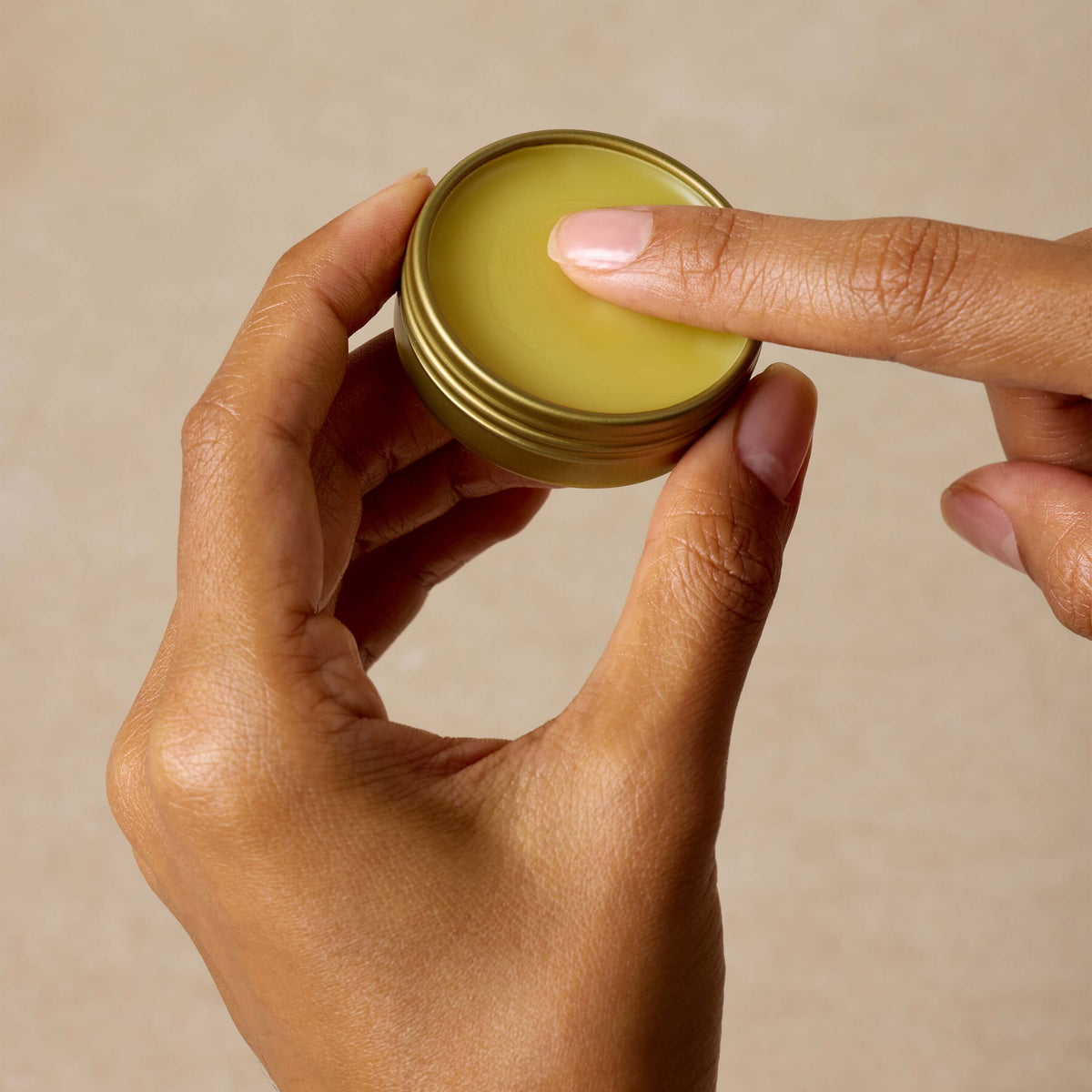 woman-dips-her-finger-in-shea-butter-salve