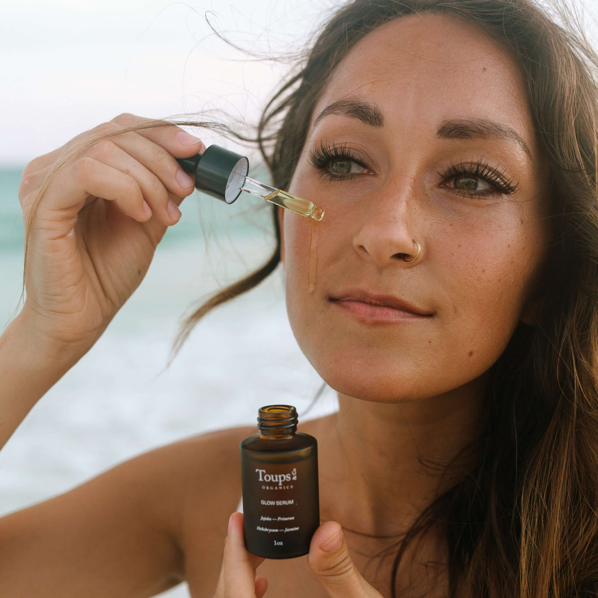 woman-applies-brightening-serum-to-her-cheeks